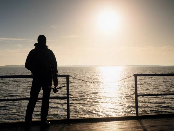 Mann, Fotograf beim Fotografieren am See bei Sonnenuntergang. Hobbyfotograf im Urlaub. — Stockfoto