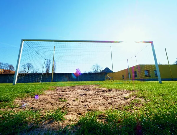 Pendurar redes de futebol amarelo azul dobrado, futebol líquido. Grama no campo de jogos de futebol no fundo — Fotografia de Stock