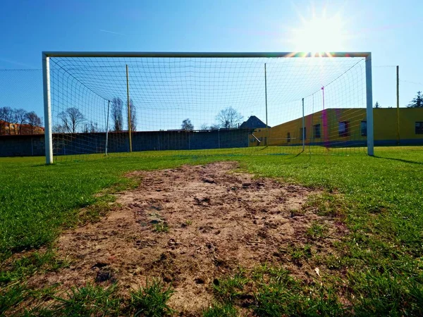 Cuelgue doblado azul amarillo redes de fútbol, fútbol red de fútbol. Hierba en el patio de fútbol en el fondo — Foto de Stock