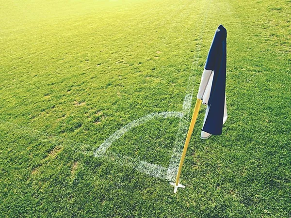Vit blå flagg i hörnet av fotboll lekplats, lata vinden blåser — Stockfoto