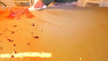 Yakından görmek güçlü erkek temizlik ölçekler ve kan tablo filleting eller. Yıkama ve in wiping balık kanı kalabalık ve ölçekler kaldırıldı.