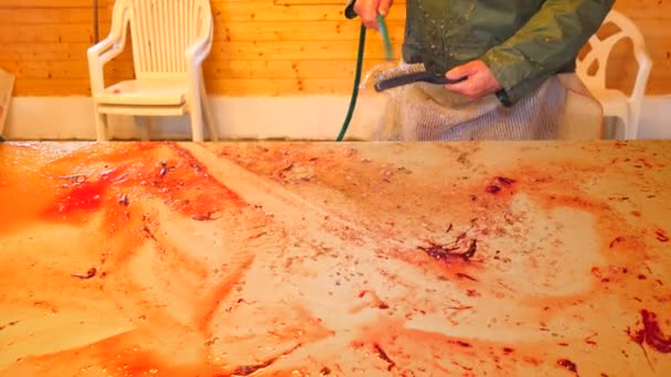 Detailní pohled silné mužské ruce čištění váhy a krev z filetování tabulka. Mytí a otírání zahlcena rybí krev a odstraněny váhy. — Stock video