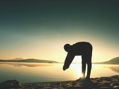 Derin nefes alma runner siluet elleriyle diz çöküyorum. Kas germe adama yan görünüm 