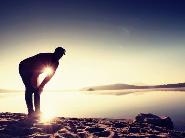 Derin nefes alma runner siluet elleriyle diz çöküyorum. Kas germe adama yan görünüm 