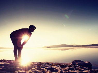 Derin nefes alma runner siluet elleriyle diz çöküyorum. Kas germe adama yan görünüm 