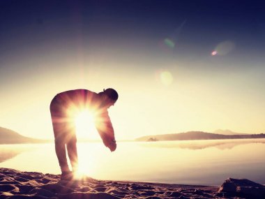 Derin nefes alma runner siluet elleriyle diz çöküyorum. Kas germe adama yan görünüm 