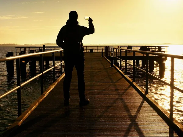 Man, photographer taking photos at lake at sunset.  Hobby photographer on vacation. — Stock Photo, Image