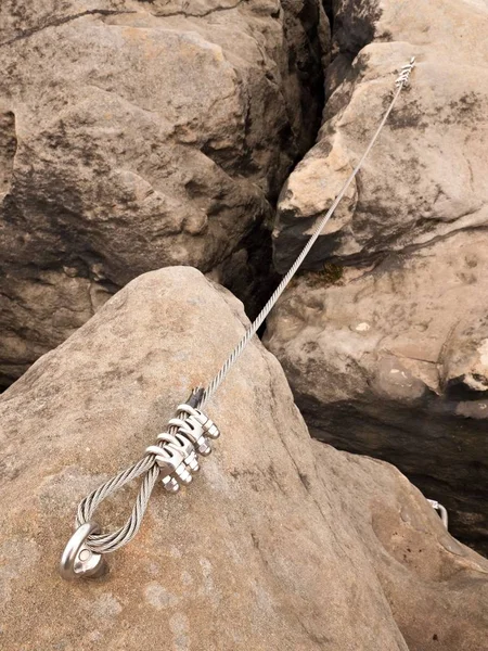 Iron twisted rope stretched between rocks in climbers patch via ferrata.  Rope fixed in rock — Stock Photo, Image
