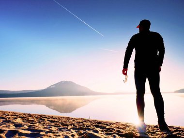 Bir spor adam elinde muhteşem günbatımı sahil gözlüklü kaldıkları ve günbatımı keyfi