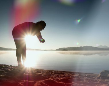 Adam atlet zaman egzersiz egzersiz okyanus plaj güneşli sabah çalıştırmak sırasında kontrol.