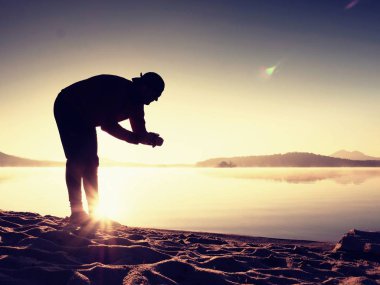 Adam atlet zaman egzersiz egzersiz okyanus plaj güneşli sabah çalıştırmak sırasında kontrol.