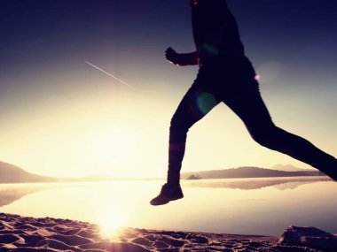 Gündoğumu kıyıda çalışan etkin atlet runner silüeti. Sabah sağlıklı yaşam tarzı egzersiz