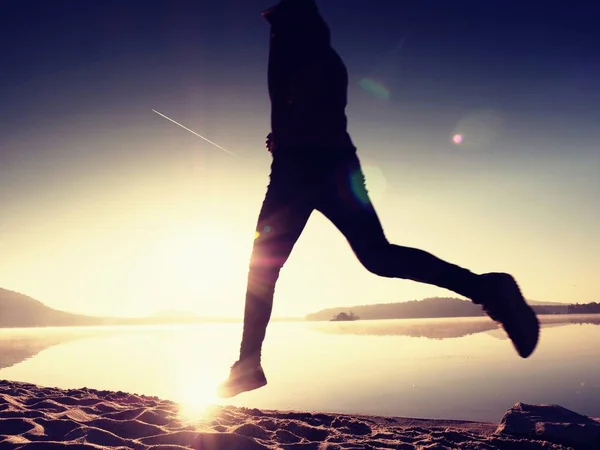 Silhueta de atleta ativo corredor correndo na costa do nascer do sol. Manhã exercício de estilo de vida saudável — Fotografia de Stock