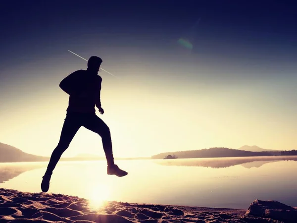 Silhouette d'athlète coureur actif courant sur le rivage du lever du soleil. Matin exercice de mode de vie sain — Photo