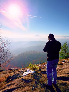 Uzun boylu adam boyunda ayna kamerayla fotoğraf çekiyorum. Dağı'nın karlı kayalık tepe. 
