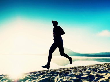 Uzun boylu deniz kıyısında sabah koşan adam uygun. Sağlıklı erkek sahilde koşu.