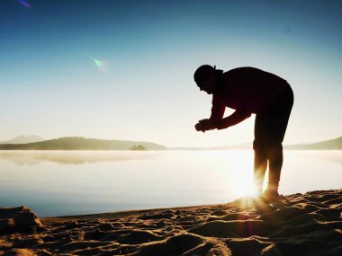 Adam atlet zaman egzersiz egzersiz okyanus plaj güneşli sabah çalıştırmak sırasında kontrol.