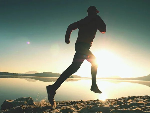Σιλουέτα του ενεργού αθλητή δρομέας τρέχει στην ακτή Ανατολή του ηλίου. Πρωινή γυμναστική υγιεινού τρόπου ζωής — Φωτογραφία Αρχείου