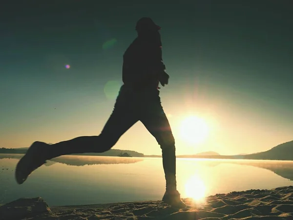 Silhouette d'athlète coureur actif courant sur le rivage du lever du soleil. Matin exercice de mode de vie sain — Photo