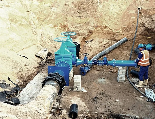 Worker underground for reconstrucion of drink water system. Technical expert at  gate valve — Stock Photo, Image