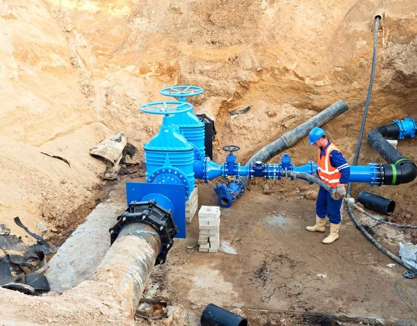 工人上闸板阀，重建的喝水系统地下 — 图库照片