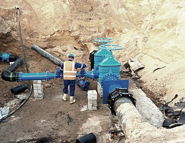 Worker underground on gate valve, reconstrucion of drink water system