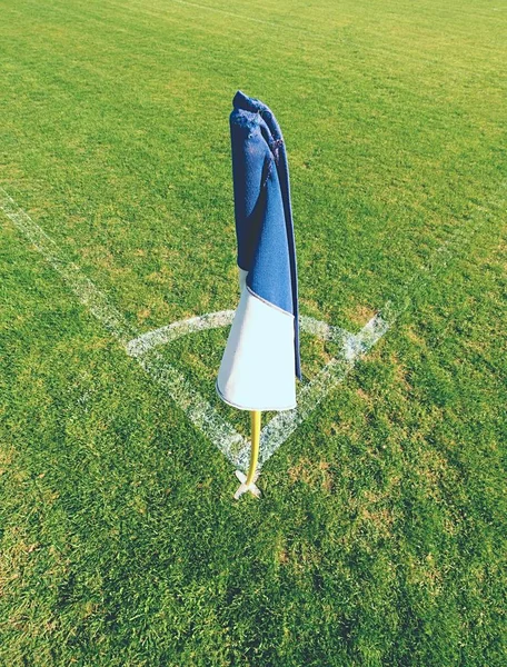 Bandeira azul branca no canto do playground de futebol, vento preguiçoso soprando — Fotografia de Stock