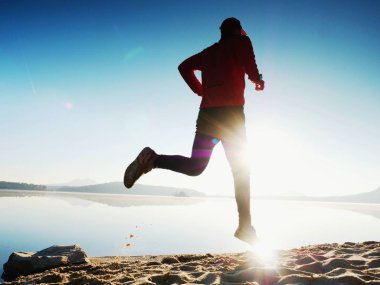 Gündoğumu kıyıda çalışan etkin atlet runner silüeti. Sabah sağlıklı yaşam tarzı egzersiz