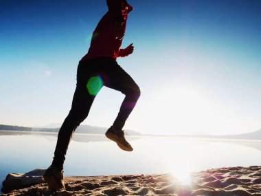 Gündoğumu kıyıda çalışan etkin atlet runner silüeti. Sabah sağlıklı yaşam tarzı egzersiz