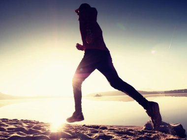 Gündoğumu kıyıda çalışan etkin atlet runner silüeti. Sabah sağlıklı yaşam tarzı egzersiz