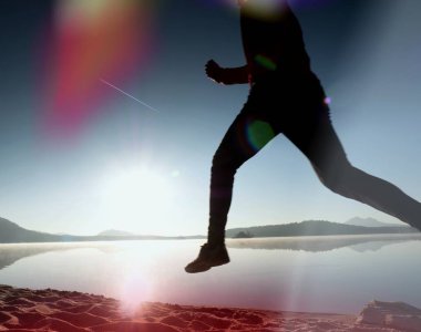 Gündoğumu kıyıda çalışan etkin atlet runner silüeti. Sabah sağlıklı yaşam tarzı egzersiz