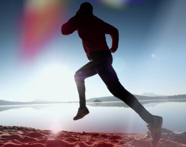 Gündoğumu kıyıda çalışan etkin atlet runner silüeti. Sabah sağlıklı yaşam tarzı egzersiz