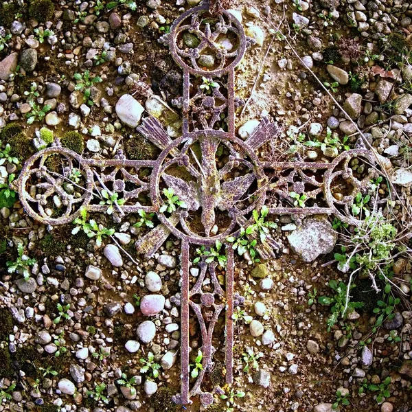 Gebroken ijzer kruisbeeld op oude mossy grafsteen — Stockfoto