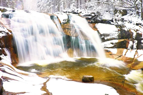 Winter besneeuwde keien en cascade van waterval. — Stockfoto