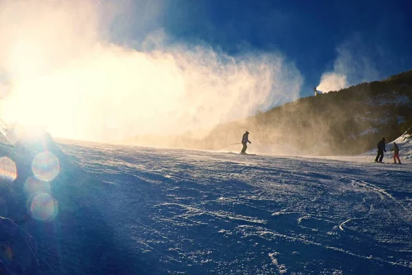 粉の雪を作る雪大砲の近くのスキーヤー。アルプス スキー リゾート. — ストック写真