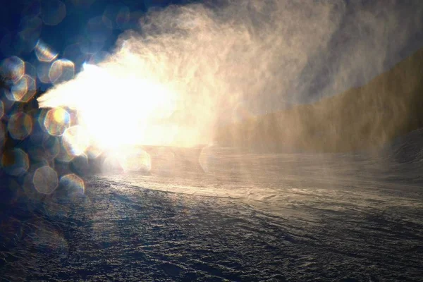 Skifahrer in der Nähe einer Schneekanone, die Pulverschnee macht. Alpen-Skigebiet. — Stockfoto