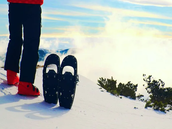 Esquiador en chaqueta de invierno roja con divertidas raquetas de nieve permanecer en la nieve en las montañas . — Foto de Stock