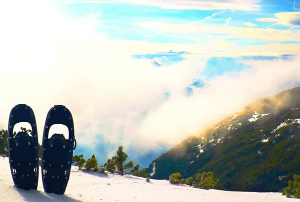 Raquetas de nieve en la nieve en la cima de la montaña, bonito día de invierno soleado —  Fotos de Stock