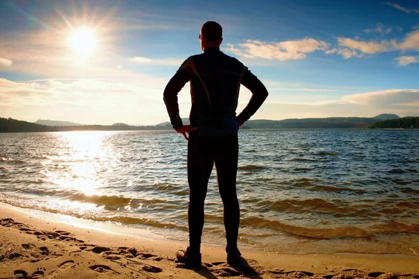 Silhuett av sport aktiv vuxen man kör och tränar på stranden. Lugnt vatten — Stockfoto