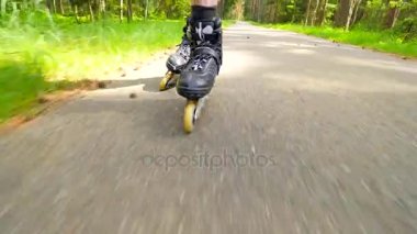 Açık shuffle paten. Bacaklar paten orman asfalt yol üzerinde mans. Hızlı karıştırma hareketi satır içi çizme görünümüne kadar kapatın.