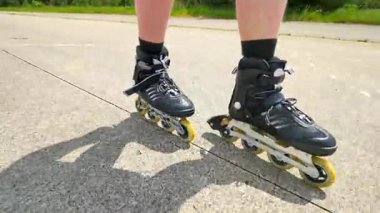 Bacaklar paten asphal üzerinde mans. Satır içi çizme hızlı hareket görünümüne kadar kapatın.