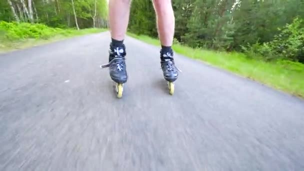 Backwards inline skating and braking on the asphalt. Close up view to move man legs and slow down. Easy backwards ride and slowing down. — Stock Video