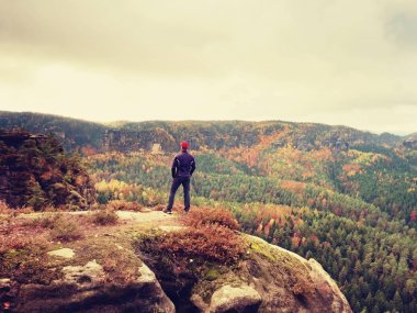 Uzun yürüyüşe çıkan kimse spor içinde ayağa rock ve güneş için sonbahar renkli Vadisi üzerinden izlerken