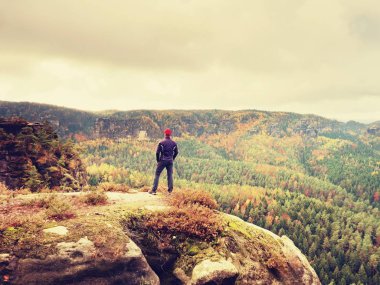 Uzun yürüyüşe çıkan kimse spor içinde ayağa rock ve güneş için sonbahar renkli Vadisi üzerinden izlerken