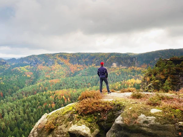 Alone hiker în stand capac roșu pe vârful de piatră de gresie în parc imperii rock și ceas — Fotografie, imagine de stoc