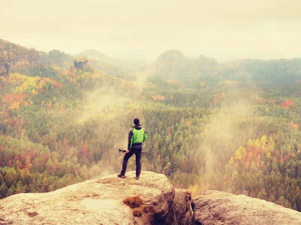 L'uomo scatta foto con smart phone sulla vetta dell'impero rock. Autunno colorato da sogno nella natura — Foto Stock