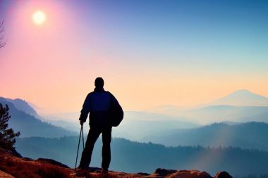 Turist ile silüeti el Polonyalılar. Uzun yürüyüşe çıkan kimse sportif sırt çantası ile kayalık Görünüm noktası puslu Vadisi üzerinde durmak. Rocky Dağları'nda güneşli sabah.