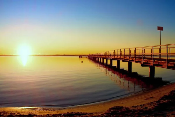 港のロマンチックな朝。海の上の観光客橋脚工事。日当たりの良い澄んだ青い空 — ストック写真