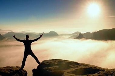 Zıplama eğlence uzun yürüyüşe çıkan kimse siyah zaferi kutlamak. İki kayalık tepeler arasında kal. Harika puslu daybreak.