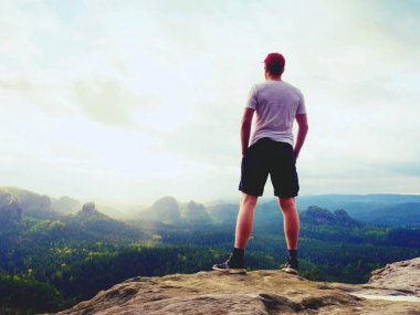 Adam tişört ve pantolon. Turizm peyzaj seyir dağ tepe üzerinde.